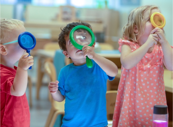 Little boy looks through the magnifying glass